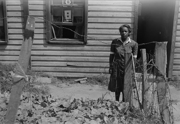 Woman standing by front yard vegetable garden
